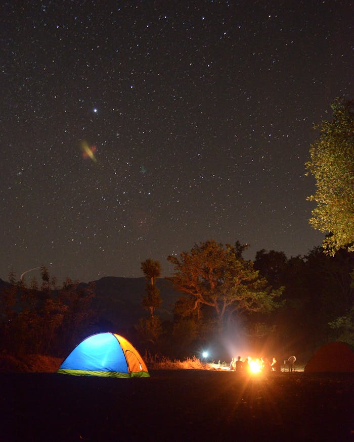 Crafting Captivating Headlines: Your awesome post title goes here Outdoor camping under a starry night sky with a glowing tent and campfire.